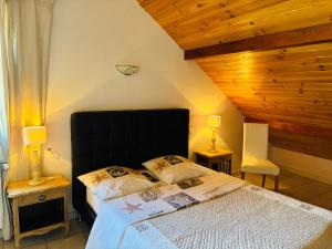 a bedroom with a large bed and two lamps at Le Rocher des Ducs, Chambres d'hôtes, parking privé, abris motos in Le Glaizil
