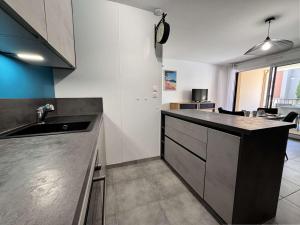 una cucina con un lavello e un piano di lavoro di Appartement 3 pièces climatisé avec parking - Saint-Cyr-sur-Mer - FR-1-845-3 a Saint-Cyr-sur-Mer Altre 8 foto
