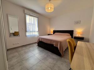 una camera da letto con un letto, un tavolo e una finestra di Appartement 3 pièces climatisé avec parking - Saint-Cyr-sur-Mer - FR-1-845-3 a Saint-Cyr-sur-Mer