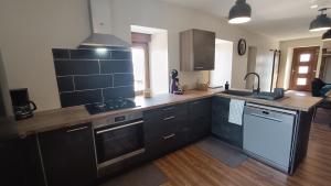 a kitchen with black cabinets and a counter top at la maison de pejusclat in Villesèque +24 photos