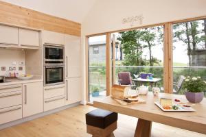 a kitchen with a table and a large window at House 29 in Looe