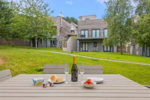 a picnic table with a bottle of wine and fruit on it at House 3 in Looe