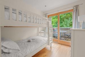 a bedroom with a bunk bed and a balcony at House 3 in Looe +32 photos