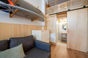 a living room with a couch and a surfboard on the wall at Suances Surf Beach in Suances