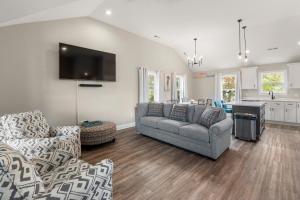 a living room with a couch and a tv at Masons Beach House Getaway in Kill Devil Hills