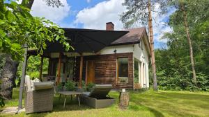 a small house with a table and an umbrella at Zakątek nad Świdrem in Otwock