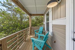 two blue chairs on the porch of a house at Masons Beach House Getaway in Kill Devil Hills