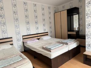 a small bedroom with two beds and a cabinet at Jany Tilek in Bosteri