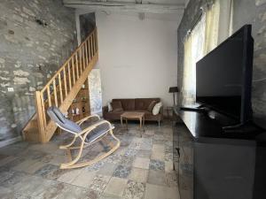 a living room with a television and a couch at Chaleureuse maisonnette au cœur de Ruoms avec terrasse et parking - FR-1-697-35 in Ruoms