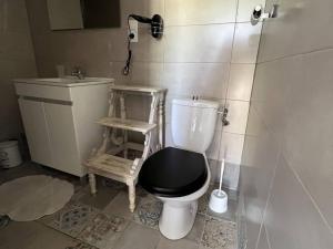 a bathroom with a toilet with a black seat and a sink at Chaleureuse maisonnette au cœur de Ruoms avec terrasse et parking - FR-1-697-35 in Ruoms +8 photos