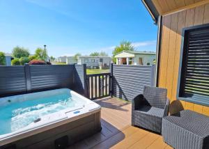 bañera de hidromasaje en una terraza con silla en Heads Of Ayr Holiday Park, en Ayr 31 fotos más