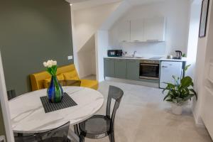 a kitchen and a table with a vase of flowers on it at Vista su Fortuna in Palestrina