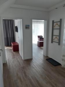 Una sala de estar con paredes blancas y una sala de estar con muebles rojos. en dat geele hus Wohnung Nr. 4, en Büsum