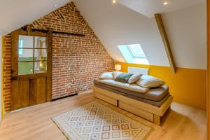 a couch in a room with a brick wall at La Richaumoise - Maison avec grand jardin in Sains-Richaumont