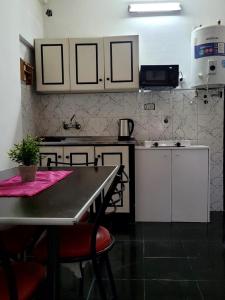 a kitchen with a table and a counter top at Zurita Apart in San Fernando del Valle de Catamarca