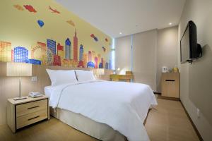 a bedroom with a large white bed and a tv at Park City Inn & Hostel in Yonghe