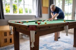 a man playing a game of pool on a pool table at Quarry House in Presteigne