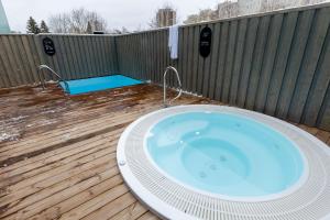 a hot tub on a deck with a fence at Ring SPA Hostel in Tallinn