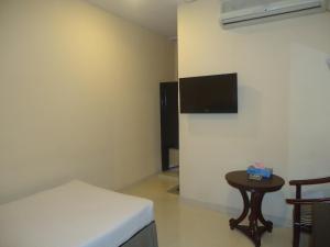 a room with a bed and a table and a tv at Executive Residence in Chittagong