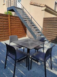 a table and chairs sitting next to a staircase at appartement en Vendée, près de circuits de rando, vélo et d'un des plus beaux villages de France in Cheffois