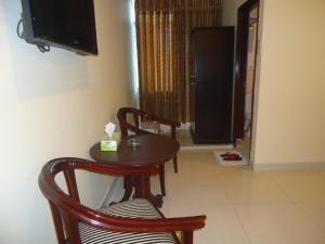 stół, 2 krzesła i telewizor w pokoju w obiekcie Executive Residence w mieście Ćottogram