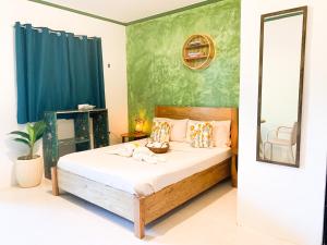 un dormitorio con una cama y un espejo en Lelija Apartment, en General Luna