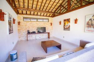 ein Wohnzimmer mit einer Couch und einem Couchtisch in der Unterkunft Villas de Fiji: Bangalô em Condomínio com Piscinas e Praia a Poucos Passos in Ilha da Restinga + 28 Fotos