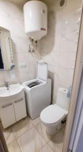 a white bathroom with a toilet and a sink at Smart House on Mashynobudivna in Kyiv