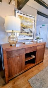 a lamp on top of a wooden entertainment center at Cosy Cottage in Harvington in Harvington