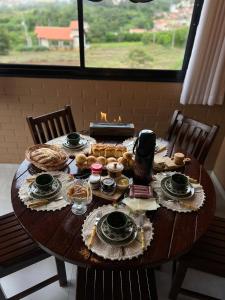a wooden table with food on it with a window at Chalé Malu in Triunfo