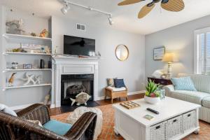 Una sala de estar con chimenea y un sofá. en Oyster Pointe E3, en Kill Devil Hills