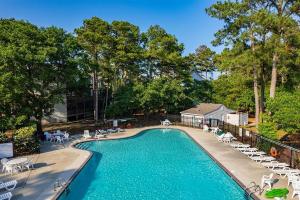 una piscina con sillas y mesas en Oyster Pointe E3, en Kill Devil Hills