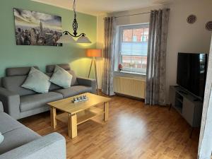 Una sala de estar con un sofá y una mesa de café. en Ferienhaus Dini, 25668, en Weener