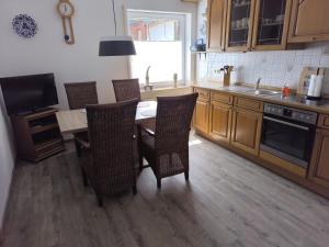 a kitchen with a table and chairs and a television at Ferienhaus Dini, 25668 in Weener