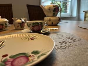 a table with a plate and a cup on it at Ferienhaus Dini, 25668 in Weener