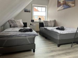 Un dormitorio con dos camas y una ventana. en Ferienhaus Dini, 25668, en Weener