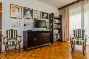 a living room with two chairs and a flat screen tv at Apartments Ružić in Split