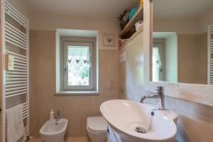 a bathroom with a sink and a toilet and a window at Cà del Lago in Sulzano +28 photos