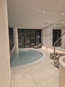 une grande piscine dans le hall de l'hôtel dans l'établissement Gold Apartment B33 Let's Sea Baltic Park Gąski, à Gąski