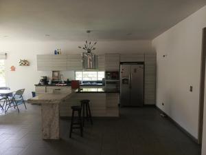 a kitchen with a refrigerator and a table and chairs at CASA QUINTA BELLO HORIZONTE in La Mesa