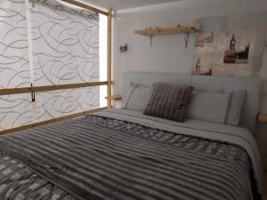 een groot bed in een kamer met een muur bij A Casa di Carla - Tiny House in SantʼAntìoco