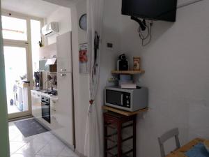 een keuken met een magnetron op een tafel met een raam bij A Casa di Carla - Tiny House in SantʼAntìoco