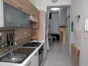 een keuken met een spoelbak en een fornuis bij A Casa di Carla - Tiny House in SantʼAntìoco