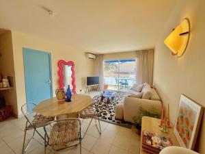 滨海卡瓦莱尔Appartement rénové 1 chambre à Cavalaire, proche plage, climatisé avec parking - FR-1-226B-107的客厅里有一张桌子和一张沙发