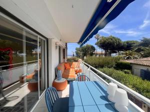 滨海卡瓦莱尔Appartement rénové 1 chambre à Cavalaire, proche plage, climatisé avec parking - FR-1-226B-107的阳台配有蓝色的桌椅