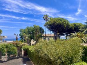 滨海卡瓦莱尔Appartement rénové 1 chambre à Cavalaire, proche plage, climatisé avec parking - FR-1-226B-107的街道上有灌木和树木的房子 更多4张照片