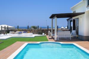 una piscina en un patio al lado de una casa en Hipoclub Villas, Alisios, en Yaiza