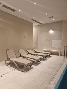 une rangée de chaises vides dans une salle d'attente dans l'établissement Gold Apartment B28 Let's Sea Baltic Park Gąski, à Gąski
