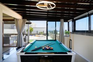 una mesa de billar en una habitación con vistas al océano en Hipoclub Villas, Alisios, en Yaiza