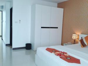 a bedroom with a white cabinet and a red towel on a bed at Grand Residence Jomtien in Jomtien Beach
